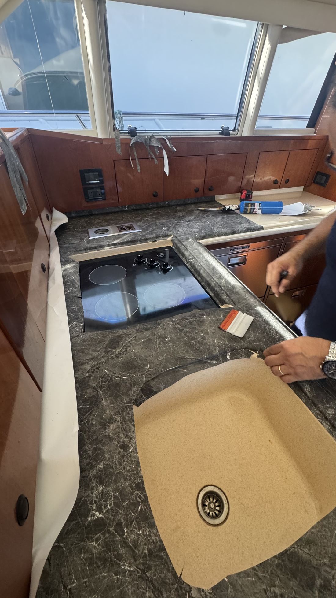 Installer applying 3M DI-NOC film to yacht countertop